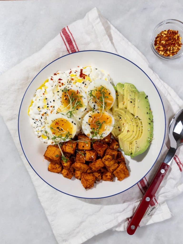 Cottage cheese breakfast bowl recipe with soft-boiled eggs, avocado, and roasted sweet potato