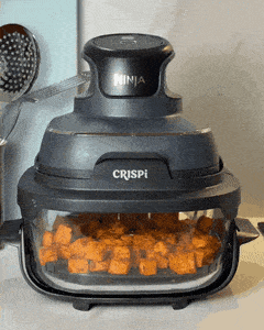 Air frying seasoned sweet potato until golden
