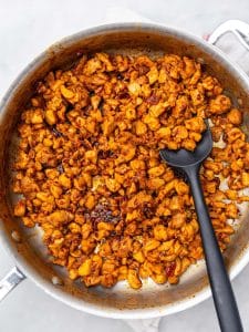 Crispy diced chipotle chicken cooking in a stainless steel skillet