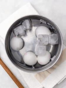 Soft-boiled eggs cooling in an ice bath for jammy yolks