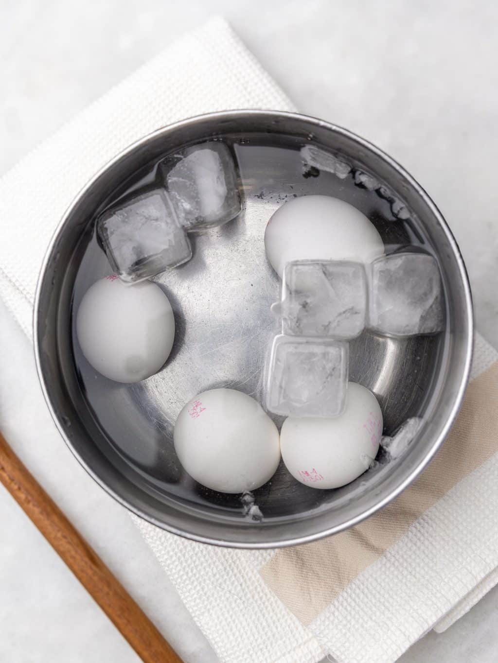 Soft-boiled eggs cooling in an ice bath for jammy yolks