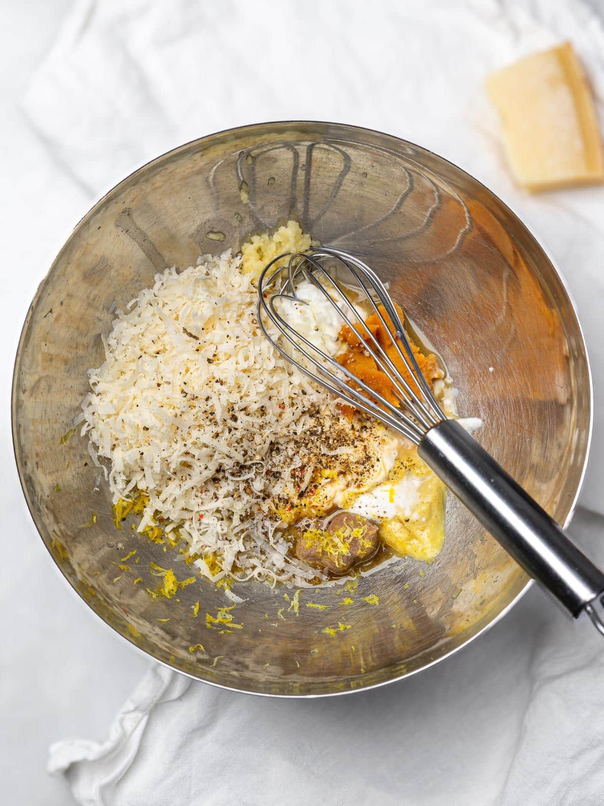 Grated parmesan, miso, lemon and mustard in a bowl before whisking