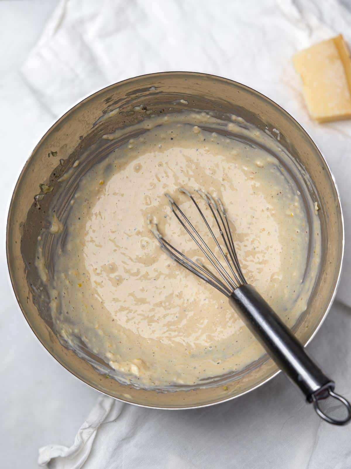 Creamy miso caesar dressing whisked in a metal bowl