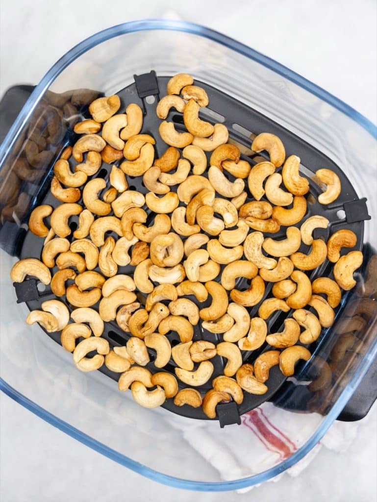 Toasted cashews in a single layer in an air fryer basket
