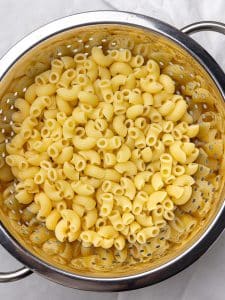 Cooked elbow pasta rinsed in a colander for buffalo chicken pasta salad