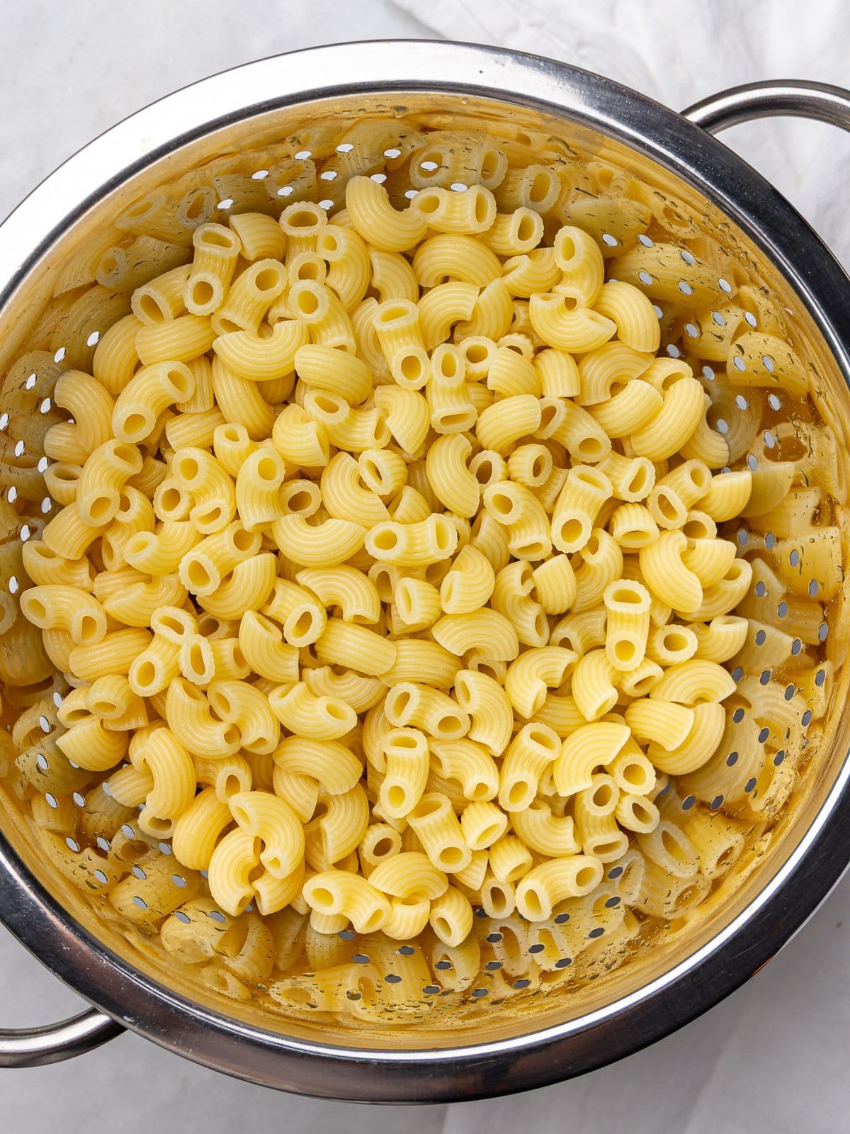 Cooked elbow pasta rinsed in a colander for buffalo chicken pasta salad