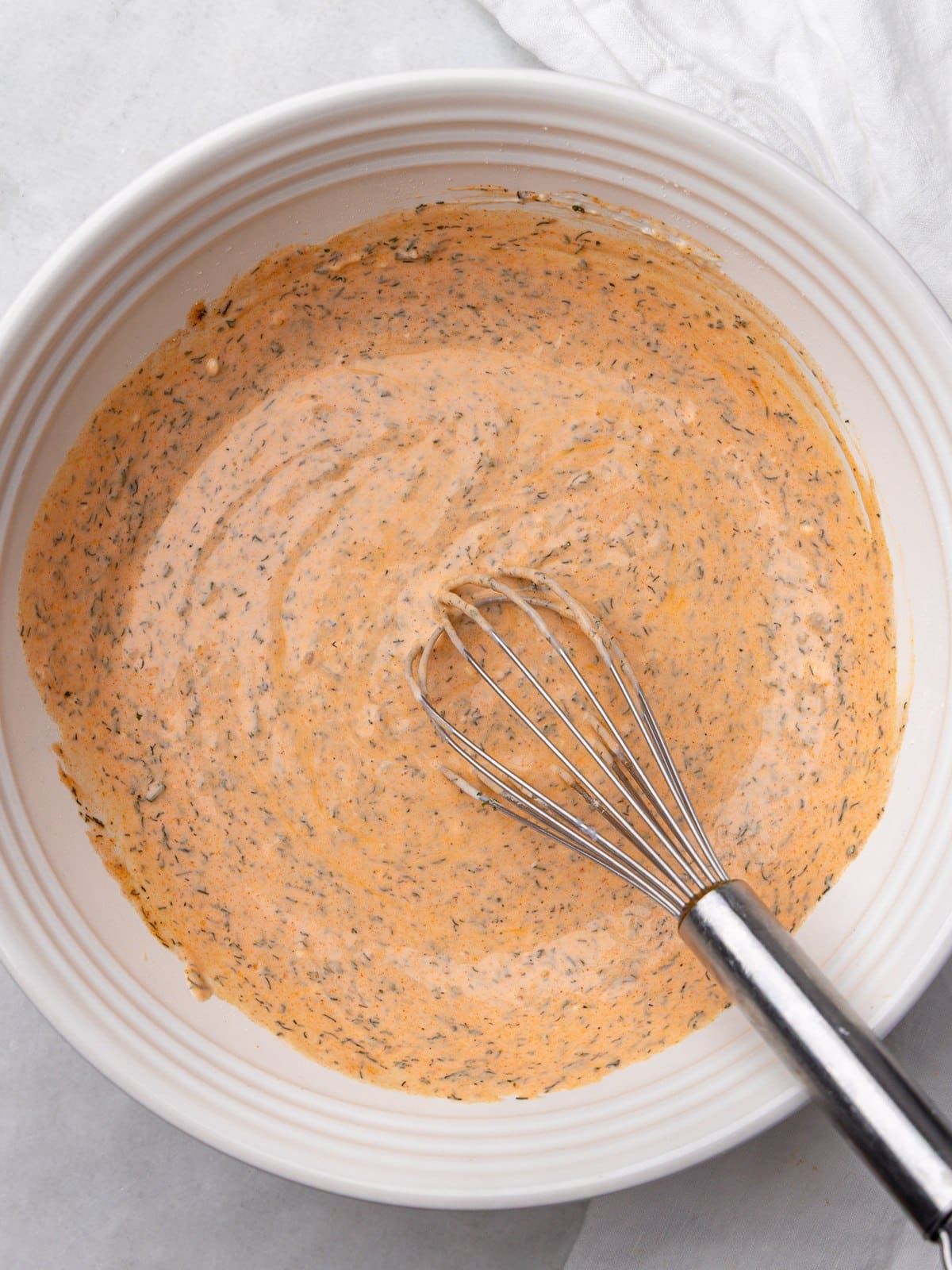 Creamy buffalo chicken pasta salad dressing whisked smooth in a white bowl