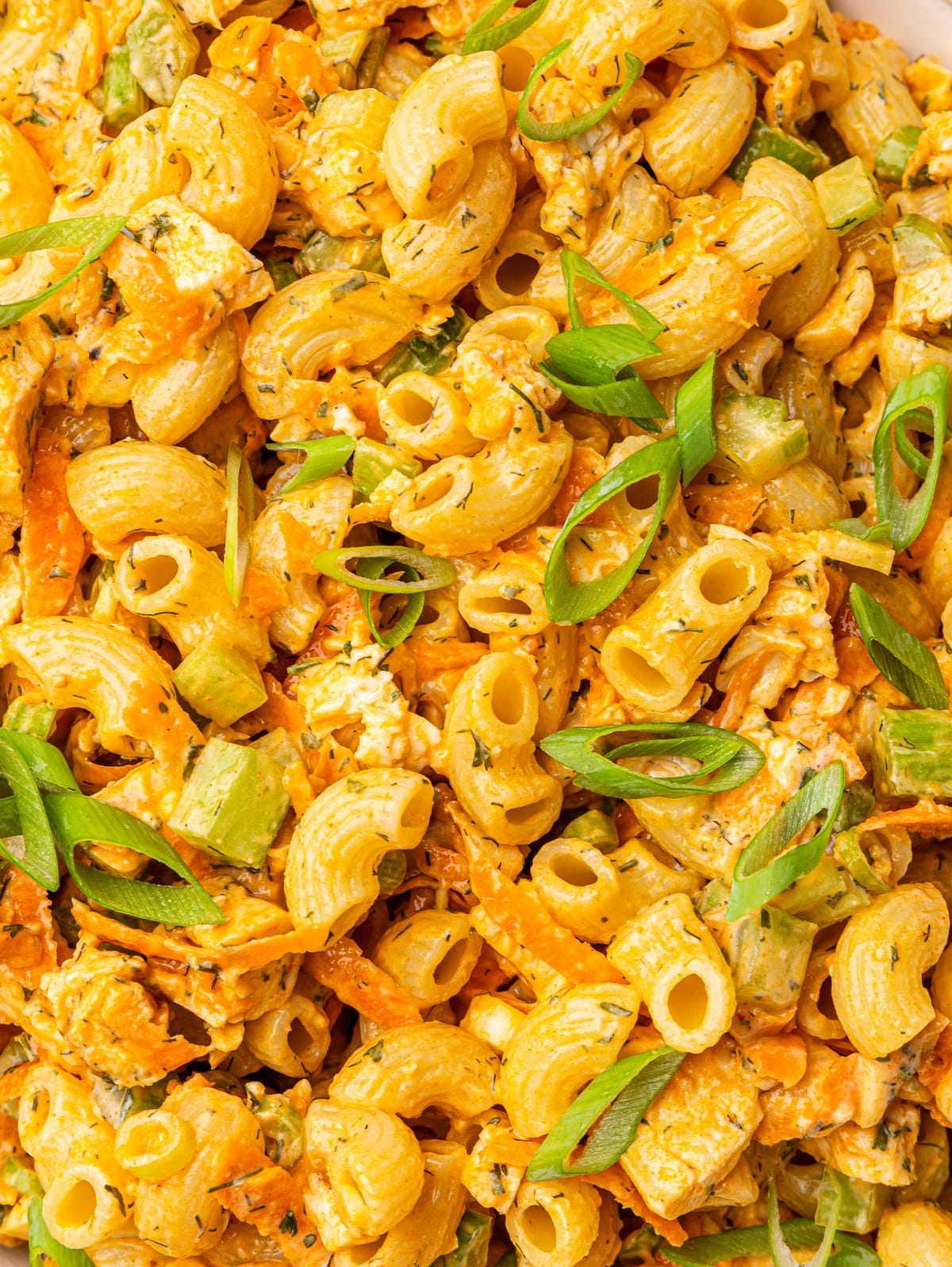 Close up of creamy buffalo chicken pasta salad showing the dressing coating every noodle