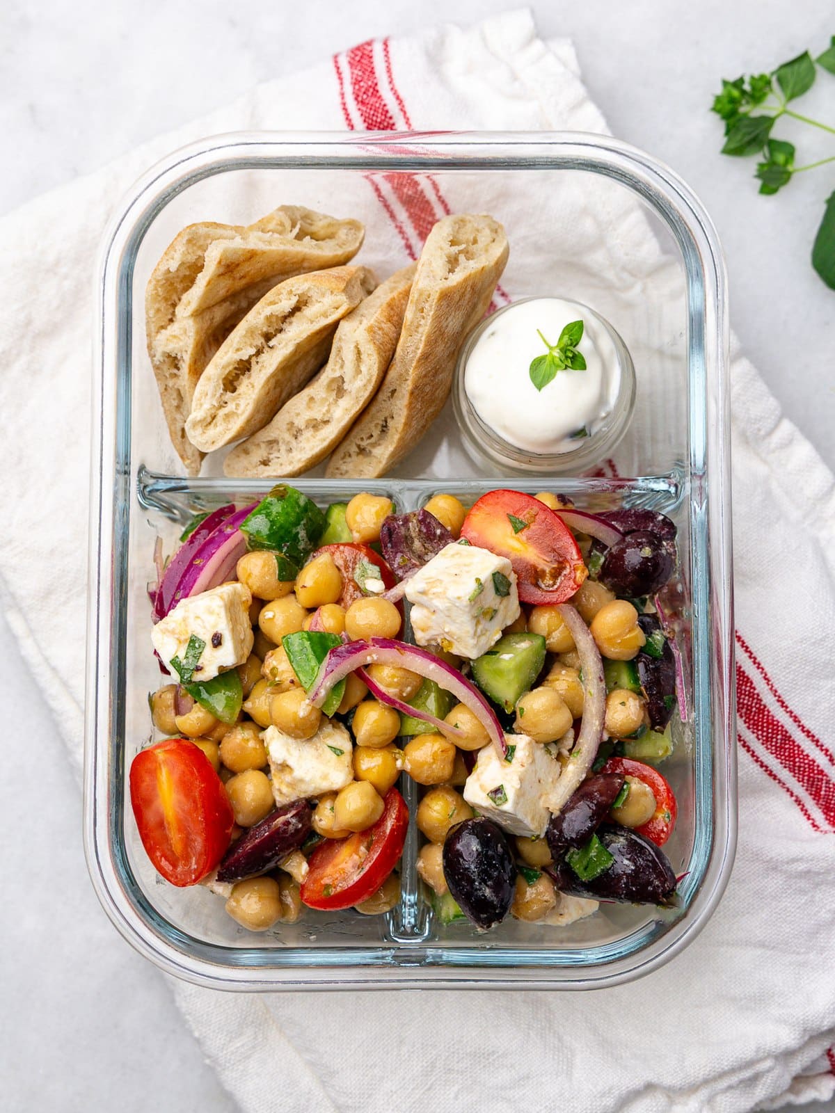 Greek chickpea salad lunch container with pita bread and greek yogurt dip
