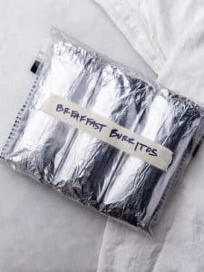 Foil wrapped high protein breakfast burritos in a labeled freezer bag