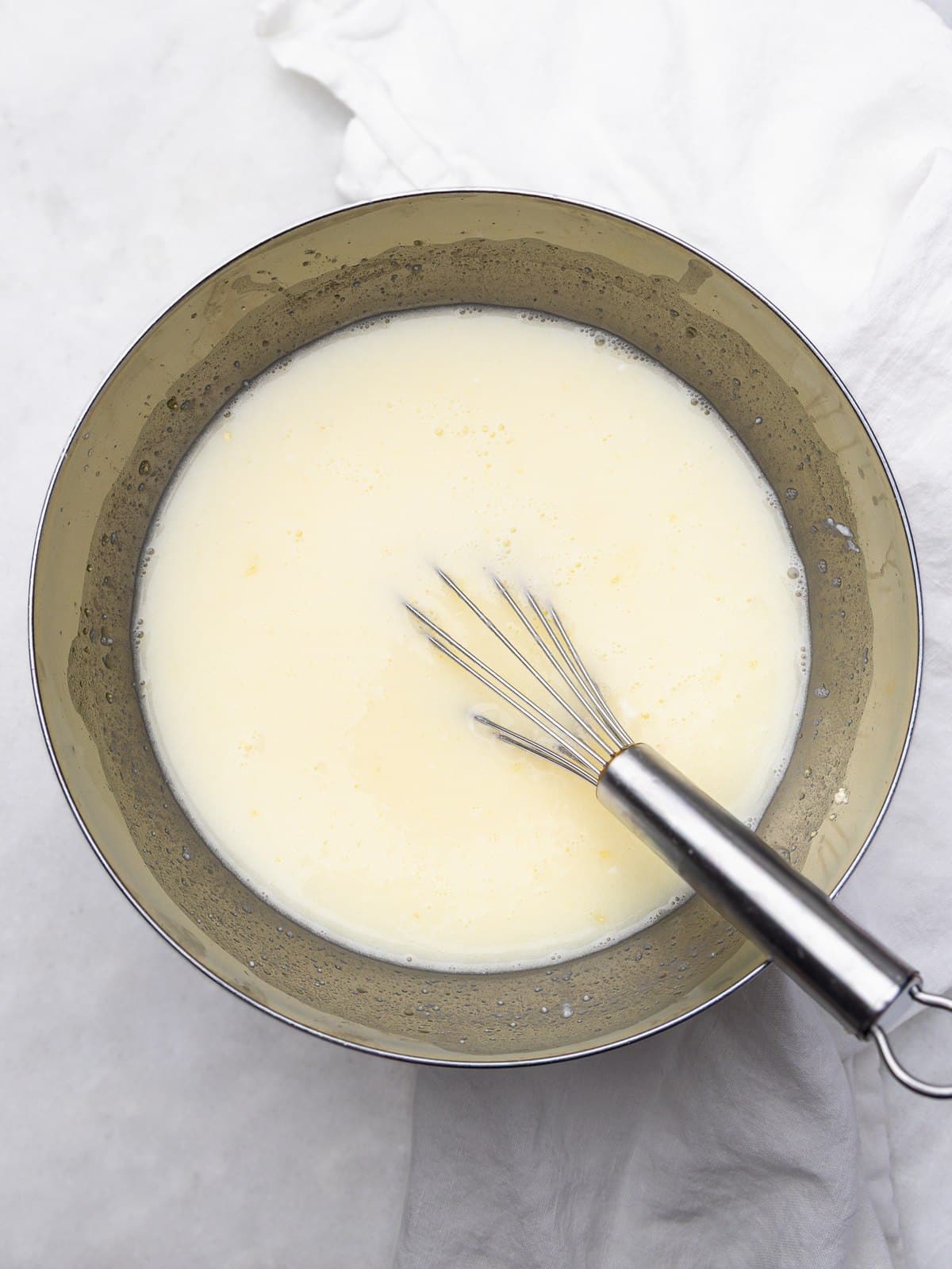 Egg whites and cottage cheese whisked together in a bowl for a high protein breakfast burrito filling