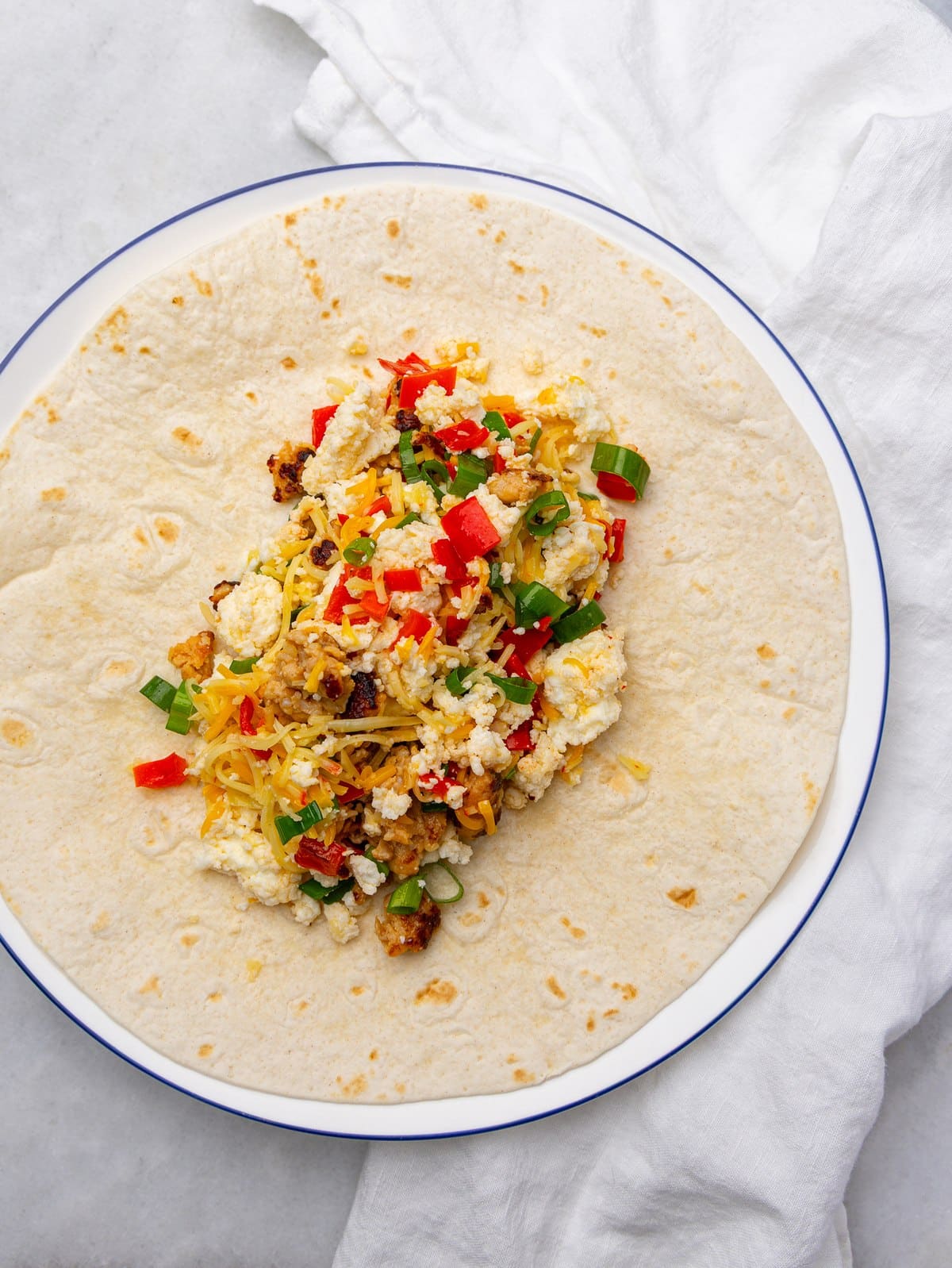Egg white and sausage filling on a low carb tortilla before rolling