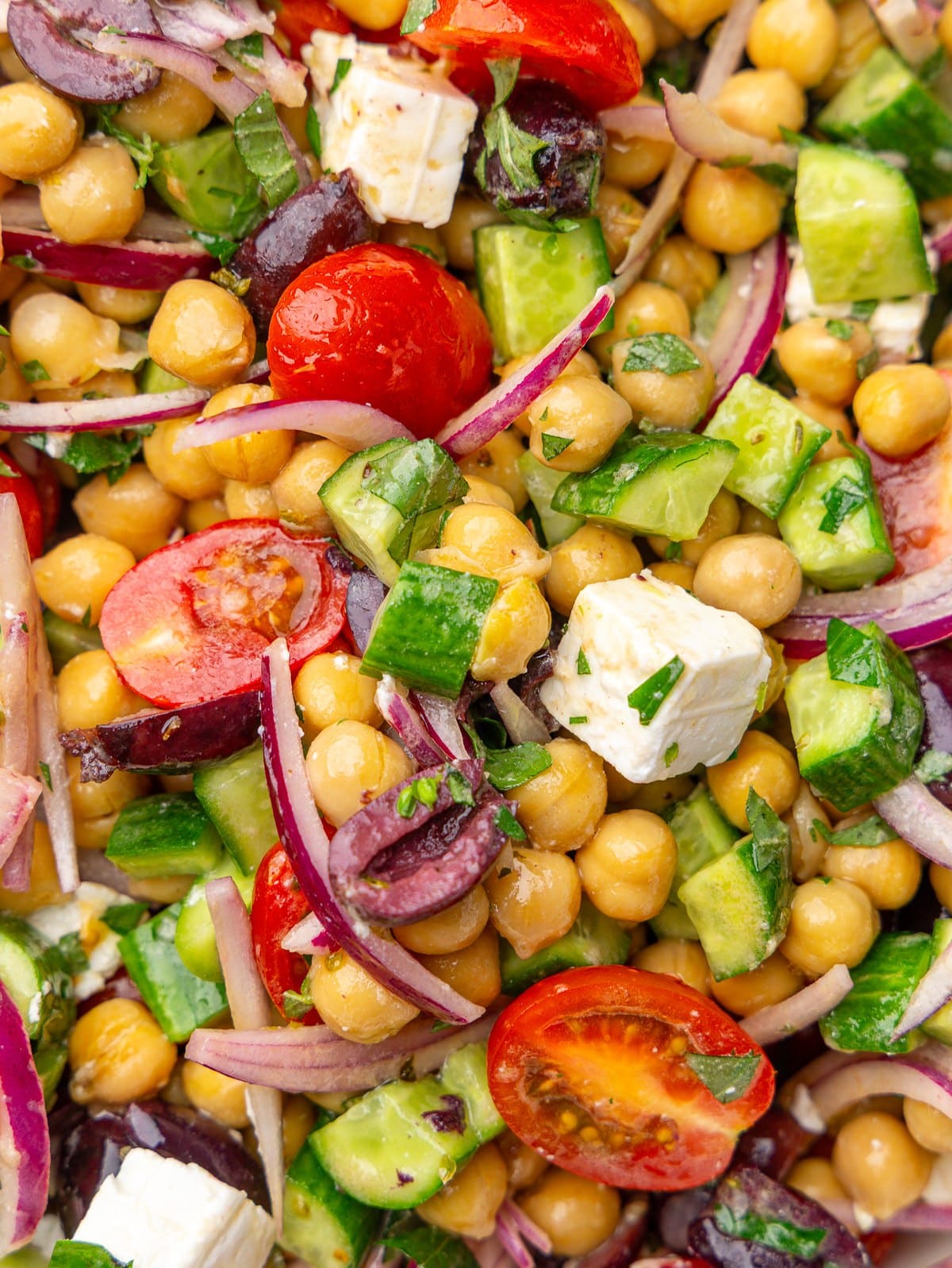 Close-up of mediterranean chickpea salad with feta, cucumber, cherry tomatoes, and red onion