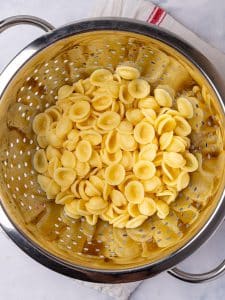 Cooked orecchiette draining in a colander, a good shape for autumn pasta recipes