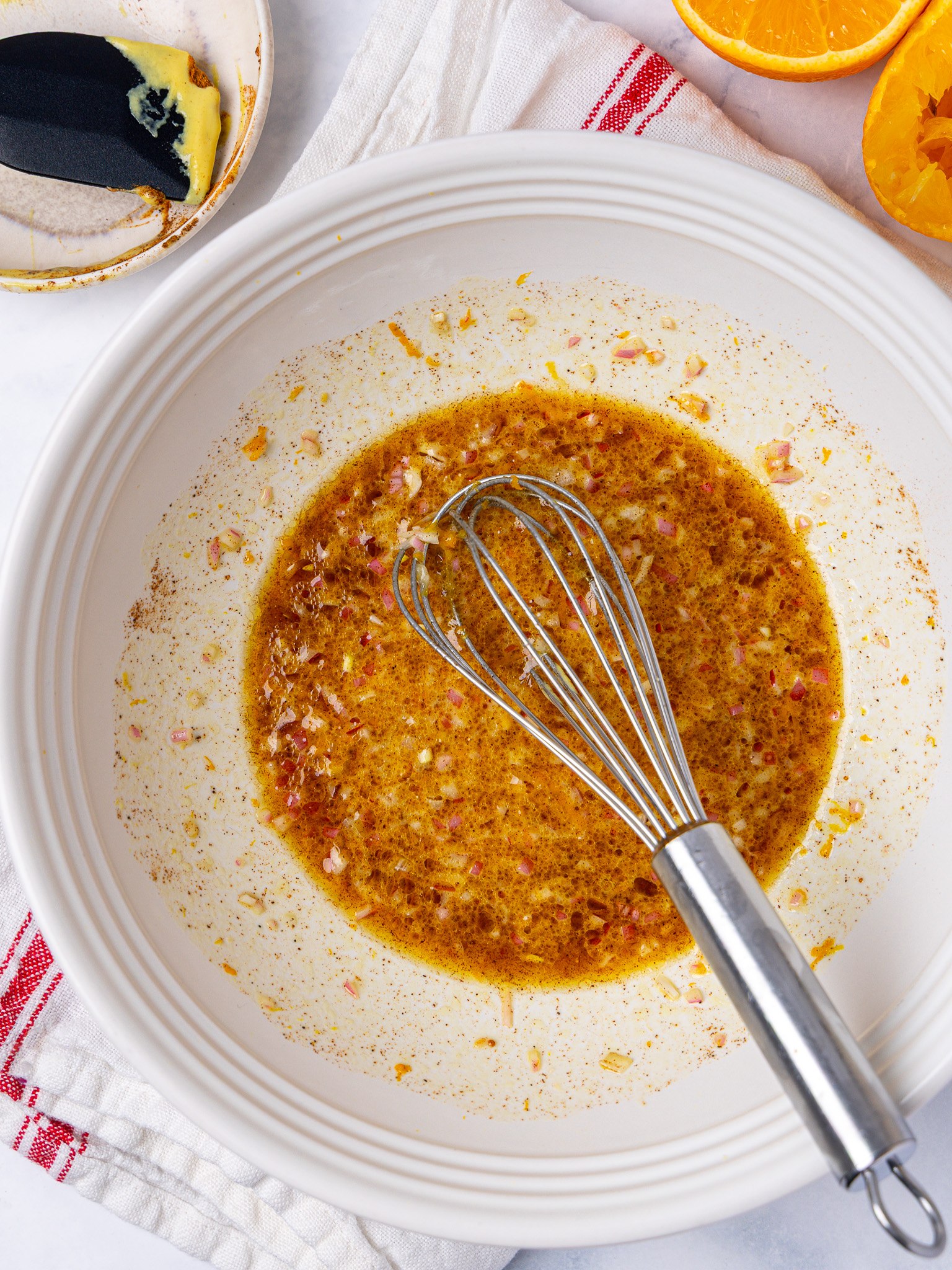 Fall pasta salad dressing with apple cider vinegar, orange and cinnamon whisked in a white bowl
