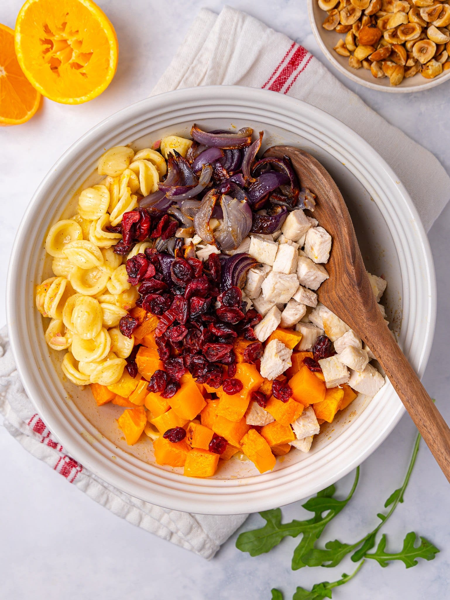 Orecchiette, roasted squash, red onion, turkey and dried cranberries in a bowl for this fall pasta salad recipe
