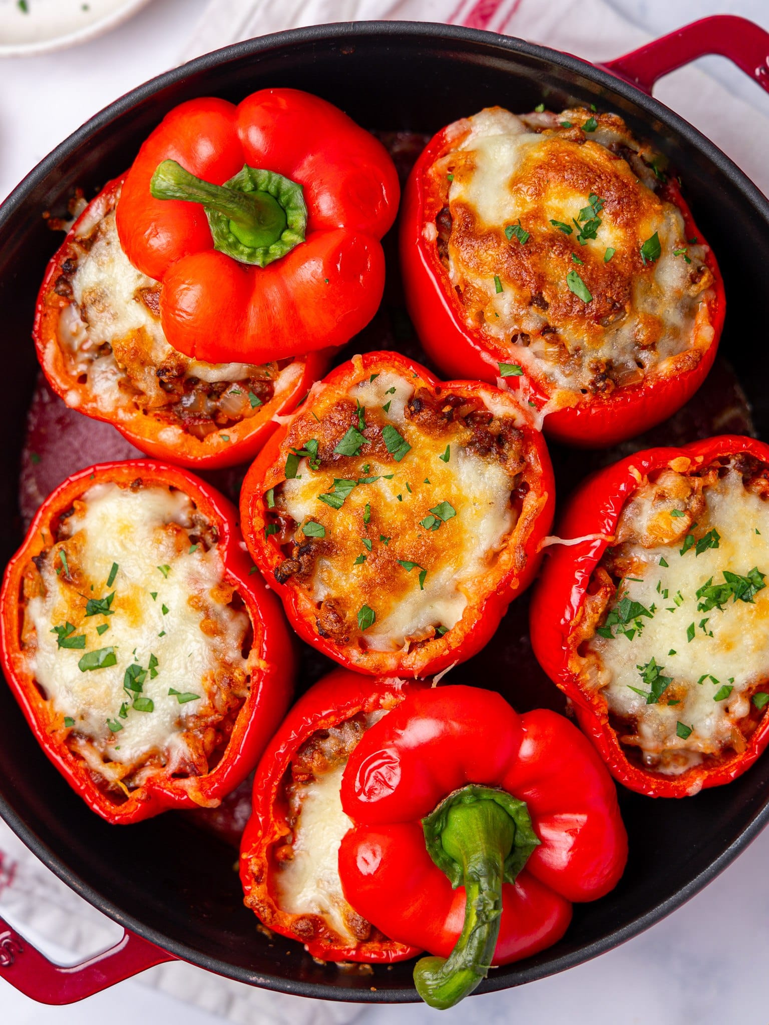 Stuffed peppers recipe with bubbly browned mozzarella and two pepper tops set back on as lids
