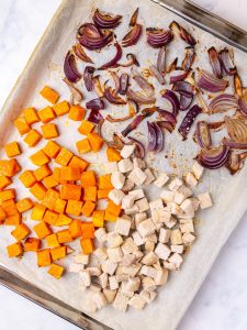 Roasted squash, red onion and diced turkey on a sheet pan, a base for Thanksgiving pasta salad recipes